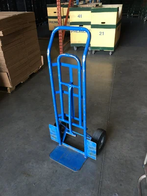 Blue metal two-wheel hand truck in a warehouse